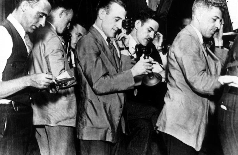 Stockbrokers reading ticker tape at the New York Stock Exchange in the 1920s
